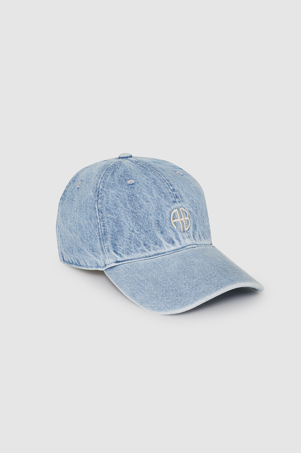 Anine Bing Jeremy Baseball Cap AB – håndlavet kasket i bleached blue denim med justerbar rem og elfenbensfarvet satinbroderi.
