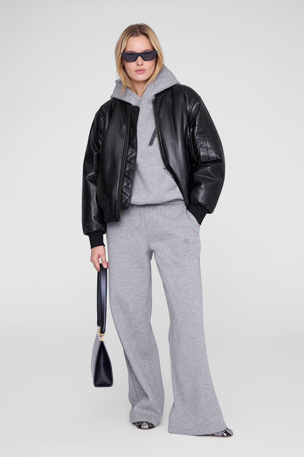 Anine Bing Kacey Sweatpant Monogram – Medium Heather Grey. Wide-leg joggingbukser i French terry bomuld med elastisk talje, skjult snøre, sidelommer og tonalt monogram.
