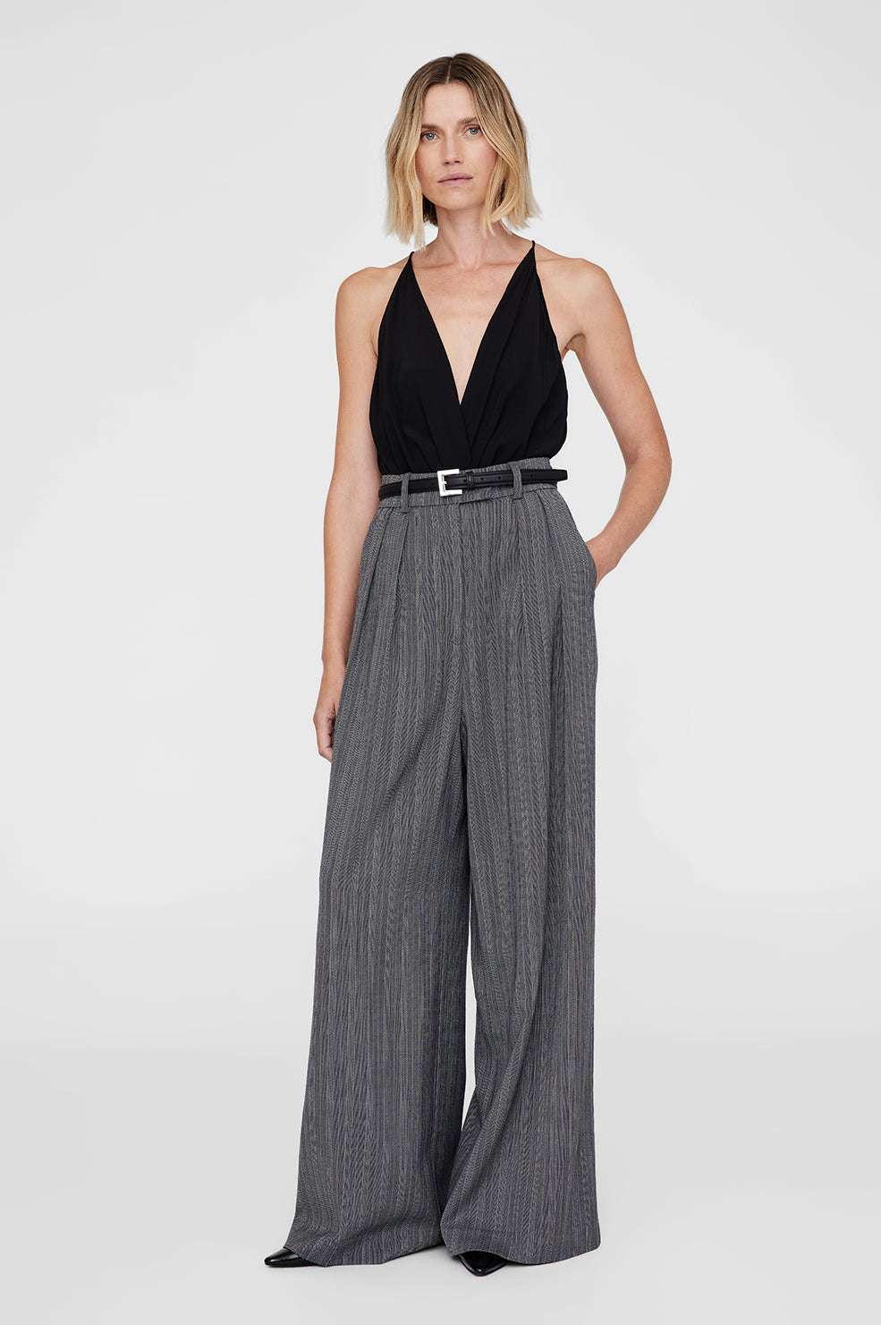 Anine Bing Nicola Belt i sort læder – let polstret bælte med firkantet sølvfarvet spænde og diskret logo.
