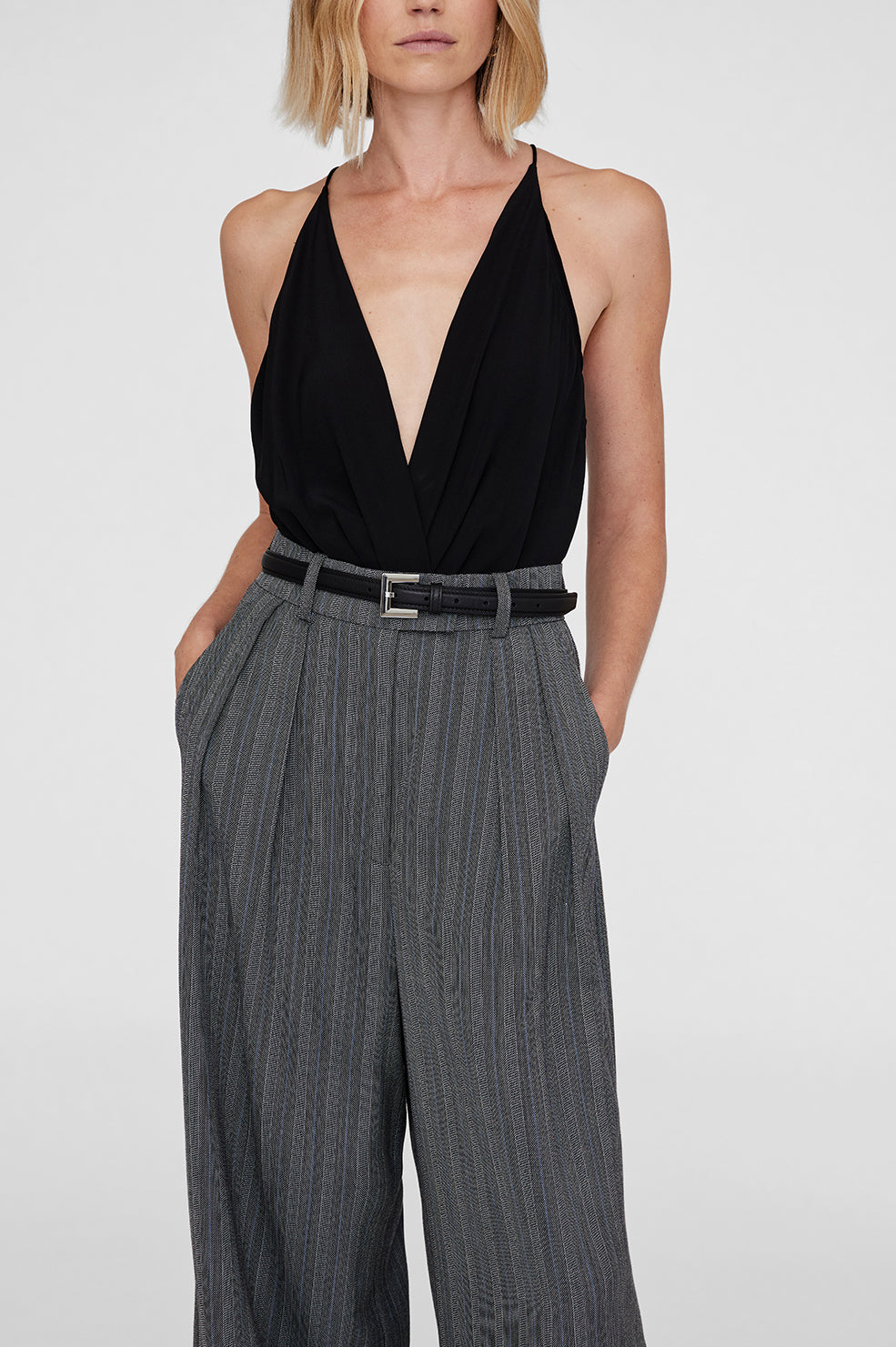 Anine Bing Nicola Belt i sort læder – let polstret bælte med firkantet sølvfarvet spænde og diskret logo.
