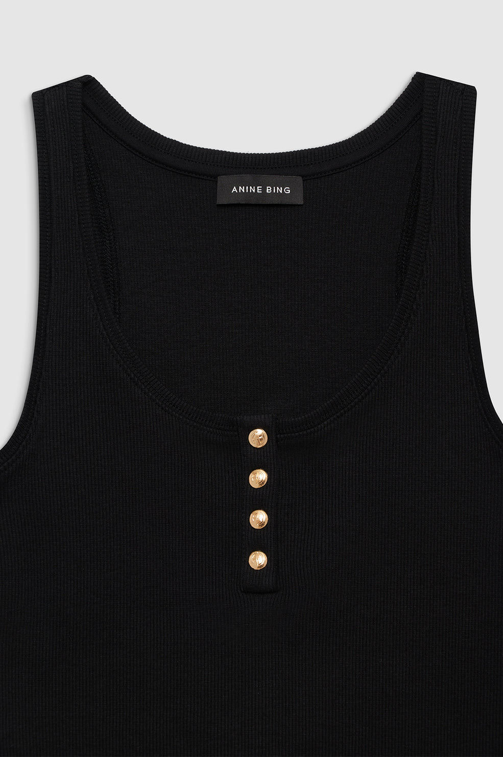 Anine Bing Alessia Tank – ribbet tanktop i bomuldsblanding med guld-monogram knapper og afslappet pasform. 