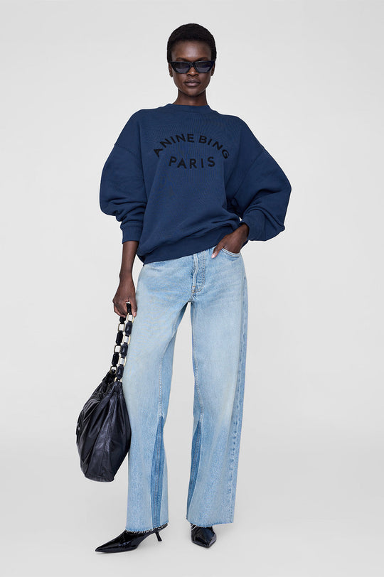 Anine Bing Jaci Paris sweatshirt i washed navy med oversized pasform, vintage-inspireret filtpatch og 100 % bomuldsfleece. Eksklusivt og komfortabelt design.