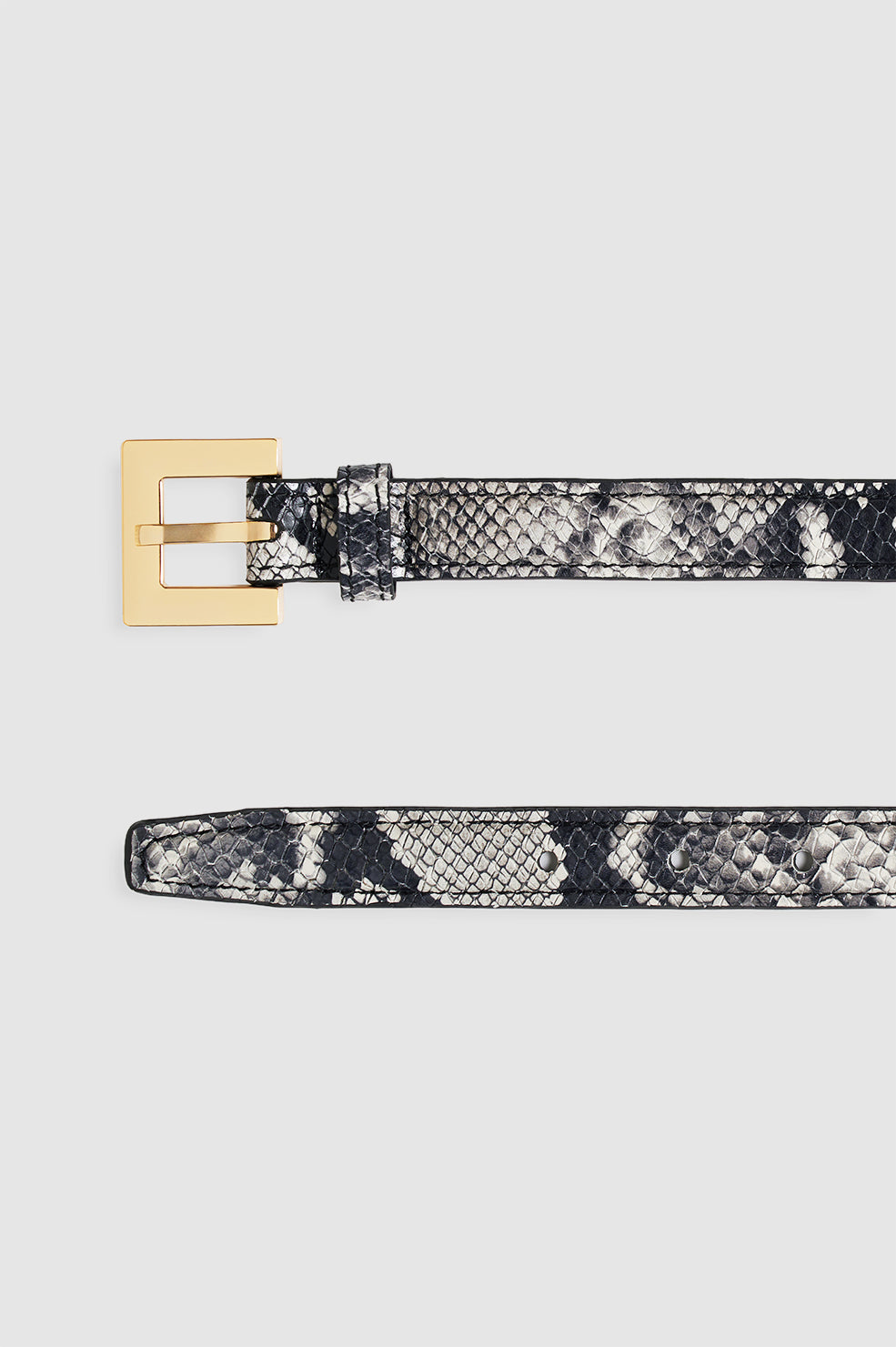 Anine Bing Nicola Belt i sort og hvidt slangeprint – smalt læderbælte med gyldent metalspænde og elegant, edgy udtryk.
