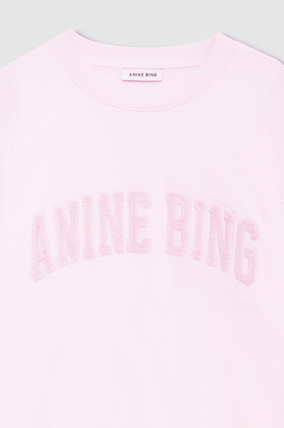Anine Bing Spencer Sweatshirt i powder pink – cropped og boxy sweatshirt i bomulds French terry med tekstureret ANINE BING-logo på brystet.

