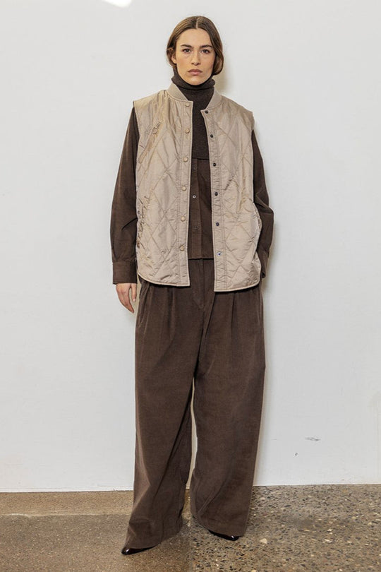 Project AJ117 Tailor Bukser i Coffee – brede bukser i blød baby-corduroy med for-pliéer, stiklommer og klassisk lynlås- og knaplukning. Fremstillet i 100% økologisk bomuld.
