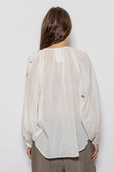 Project AJ117 Hester Bluse i White – feminin skjorte med gathered hals, raglanærmer, dekorative knapper og afrundet kant, fremstillet i 100% økologisk bomuldsvoile.
