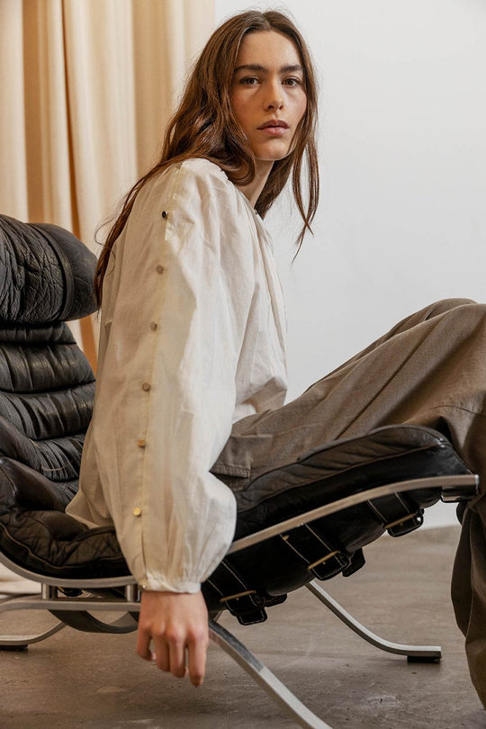 Project AJ117 Hester Bluse i White – feminin skjorte med gathered hals, raglanærmer, dekorative knapper og afrundet kant, fremstillet i 100% økologisk bomuldsvoile.
