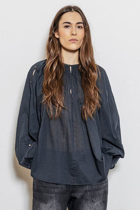 Project AJ117 Hester Bluse i Black – feminin skjorte med gathered hals, raglanærmer, dekorative knapper og afrundet kant, fremstillet i 100% økologisk bomuldsvoile.
