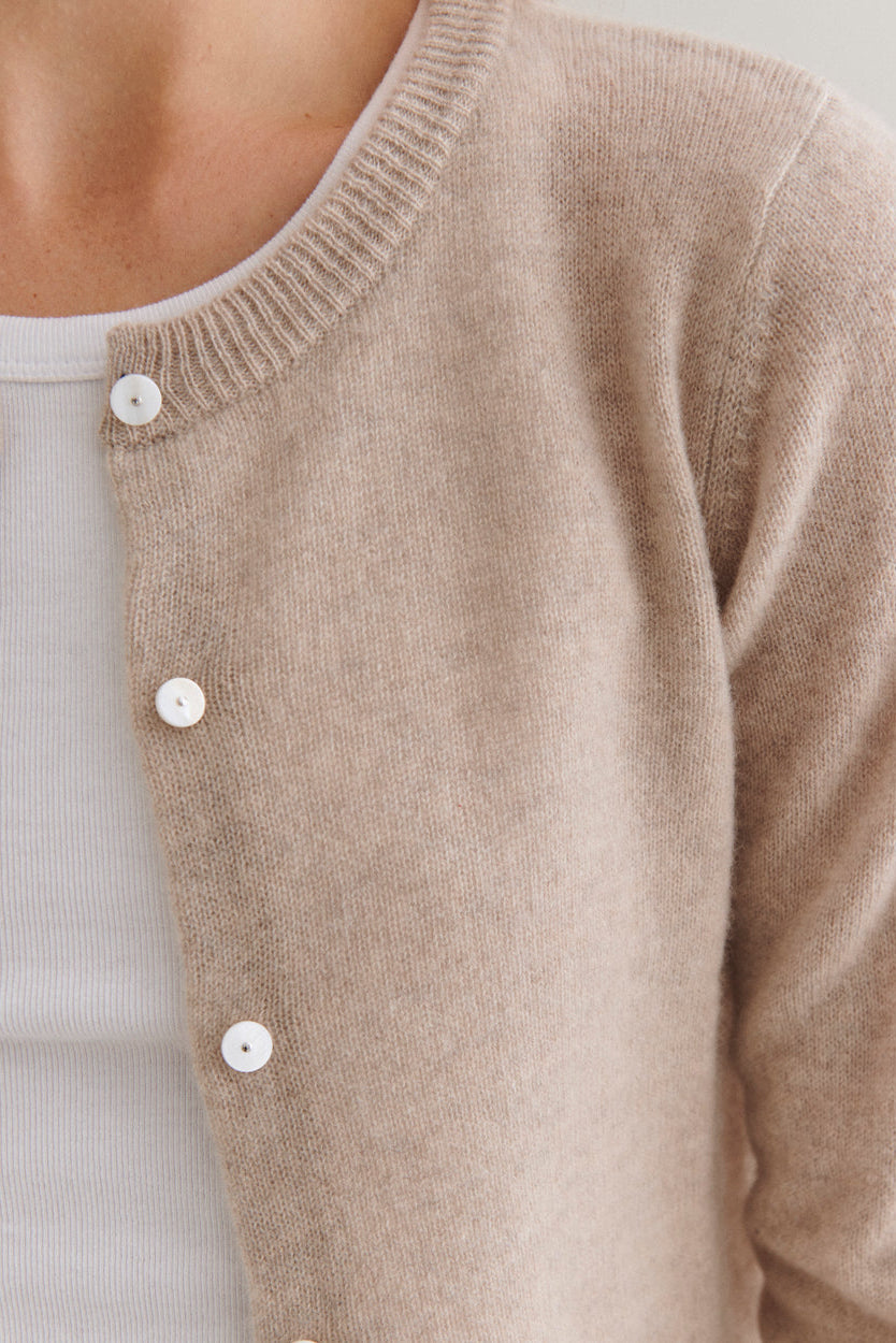 Beta Studios Classic Cardigan Cashmere i sand melange – klassisk langærmet cashmere-cardigan med ribkanter og perlemorsknapper, lavet i 100% cashmere. 
