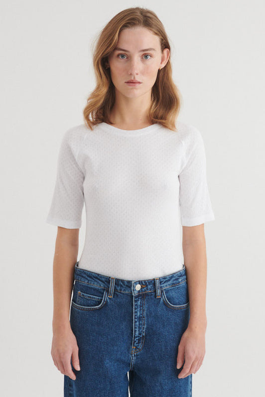 Basic Apparel Arense LS Tee i hvid med slim fit, hulmønster, raglanærmer og rund hals i økologisk bomuld.
