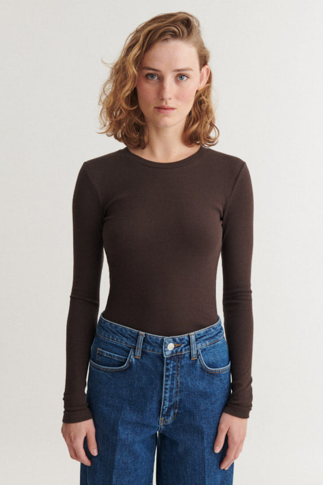 Basic Apparel Ludmilla LS Tee i chocolate torte – tætsiddende bluse i økologisk bomuld med ribstruktur, lange ærmer og afrundet hals.
