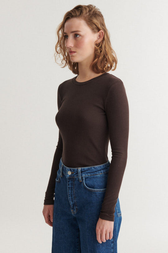 Basic Apparel Ludmilla LS Tee i chocolate torte – tætsiddende bluse i økologisk bomuld med ribstruktur, lange ærmer og afrundet hals.
