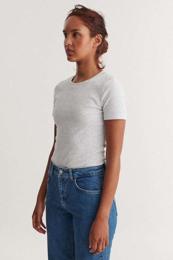 Basic Apparel Ludmilla SS O-Neck i light grey melange med ribbet struktur, tætsiddende pasform og afrundet hals i økologisk bomuld.
