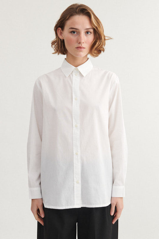 Basic Apparel Silje LS Shirt i bright white med lange ærmer, knaplukning og læg på ryggen i økologisk bomuld.

