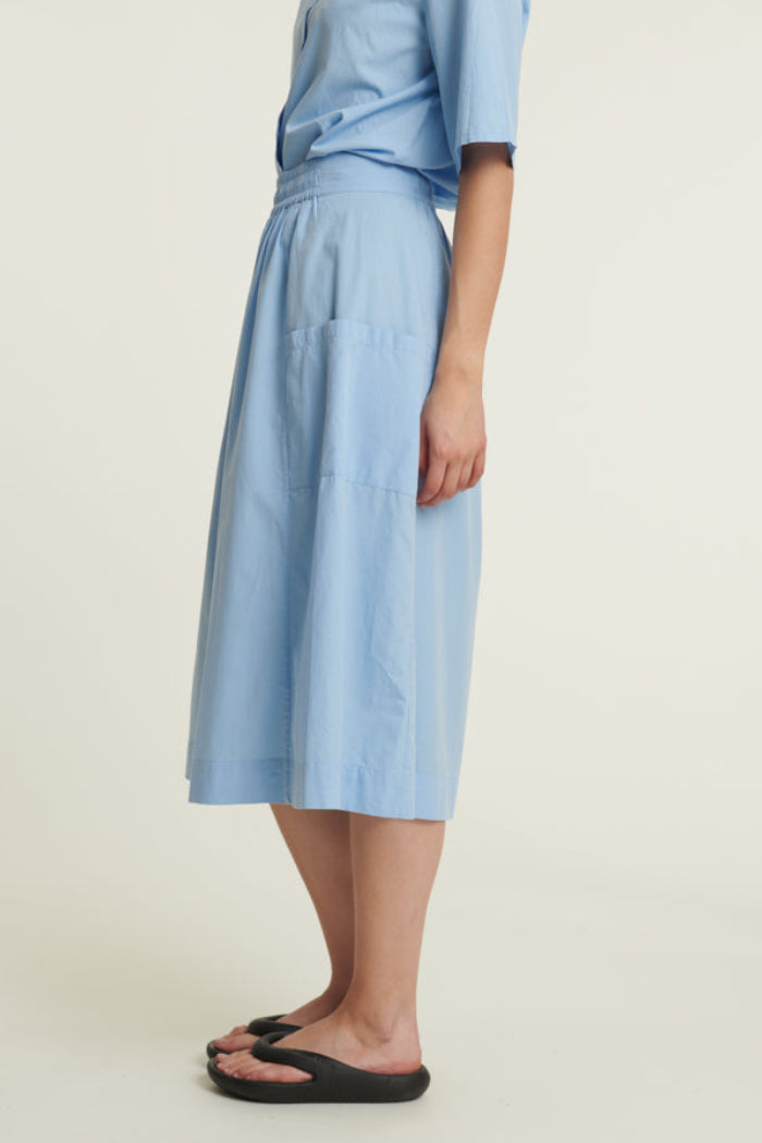 Basic Apparel Silje Skirt i frozen fjord med elastik i taljen, sidelommer og knælængde i økologisk bomuld.

