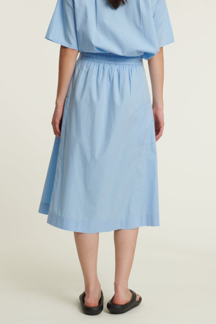 Basic Apparel Silje Skirt i frozen fjord med elastik i taljen, sidelommer og knælængde i økologisk bomuld.
