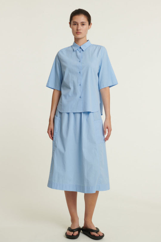 Basic Apparel Silje Skirt i frozen fjord med elastik i taljen, sidelommer og knælængde i økologisk bomuld.
