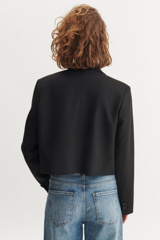 Basic Apparel Radi Short Jakke i sort – let, dobbeltradet jakke i genanvendt polyester med reverskrave og løs pasform.
