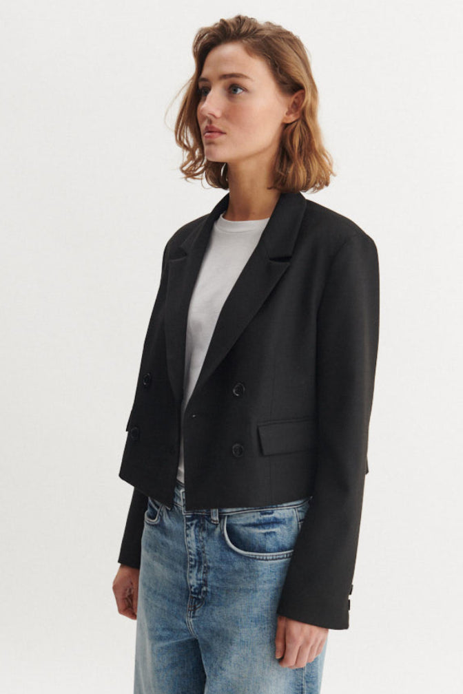 Basic Apparel Radi Short Jakke i sort – let, dobbeltradet jakke i genanvendt polyester med reverskrave og løs pasform.
