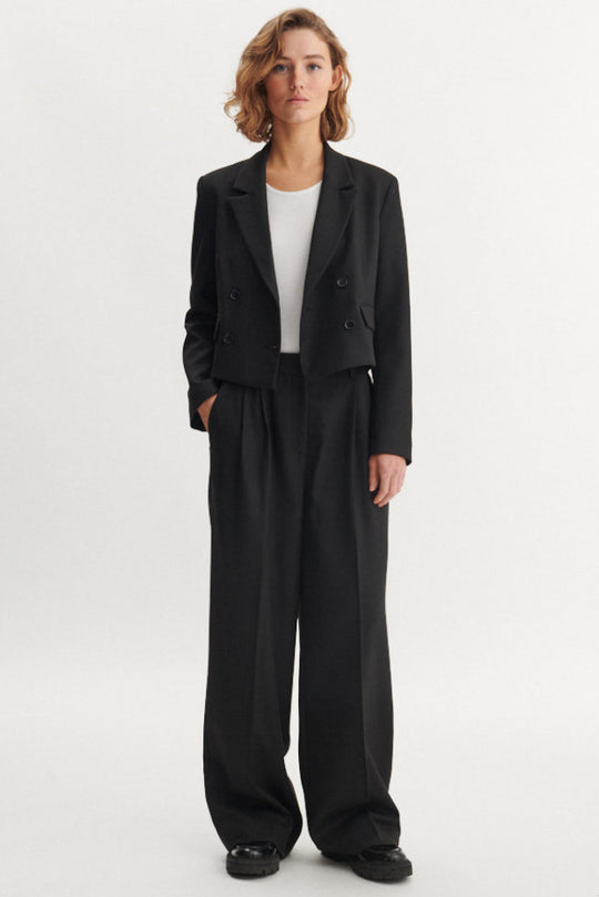 Basic Apparel Radi Short Jakke i sort – let, dobbeltradet jakke i genanvendt polyester med reverskrave og løs pasform.
