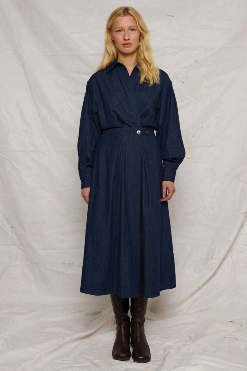 La Rouge Charlotte Dress i dark denim – langærmet kjole i let denim med skjortekrave, V-hals, markeret talje og draperet front.
