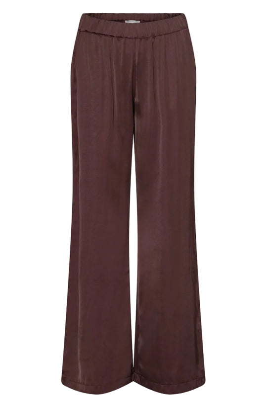 Continue Roberta Satin bukser i bordeaux med vide ben, elastik i taljen, skrålommer og satinfinish.
