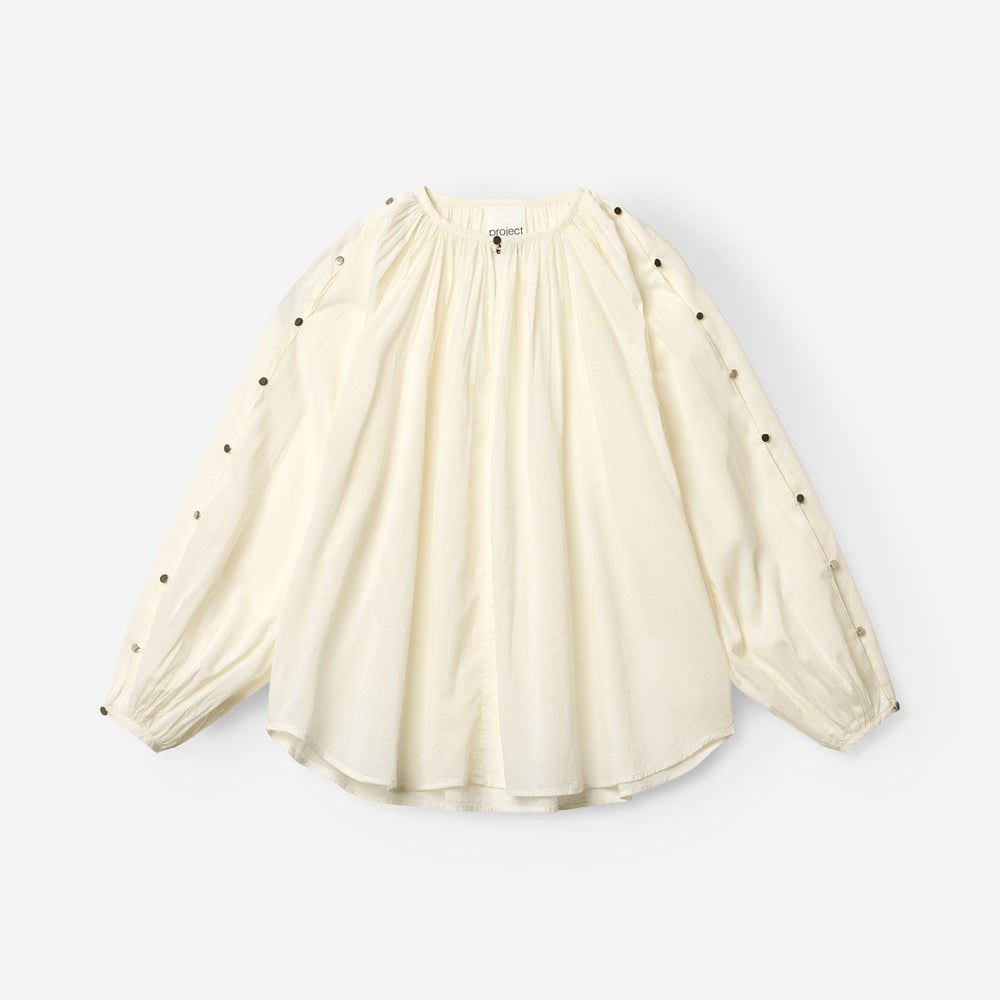 Project AJ117 Hester Bluse i White – feminin skjorte med gathered hals, raglanærmer, dekorative knapper og afrundet kant, fremstillet i 100% økologisk bomuldsvoile.
