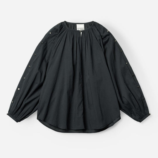 Project AJ117 Hester Bluse i Black – feminin skjorte med gathered hals, raglanærmer, dekorative knapper og afrundet kant, fremstillet i 100% økologisk bomuldsvoile.
