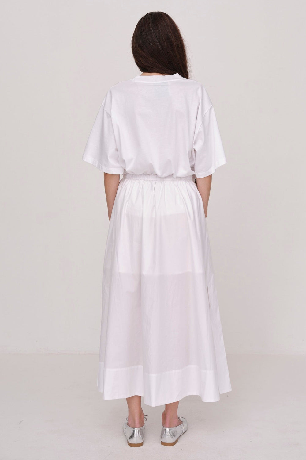 Herskind Herdis Skirt i hvid – lang, let nederdel i 100 % BCI-certificeret bomuld med elastisk talje, plisseret front og slidser i siderne. 