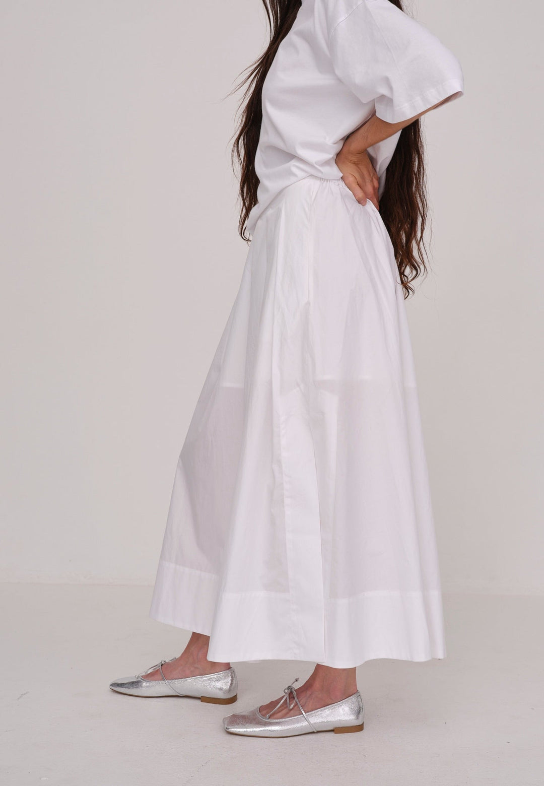 Herskind Herdis Skirt i hvid – lang, let nederdel i 100 % BCI-certificeret bomuld med elastisk talje, plisseret front og slidser i siderne. 