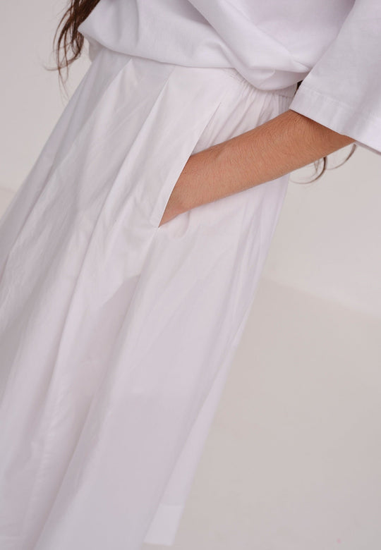 Herskind Herdis Skirt i hvid – lang, let nederdel i 100 % BCI-certificeret bomuld med elastisk talje, plisseret front og slidser i siderne. 
