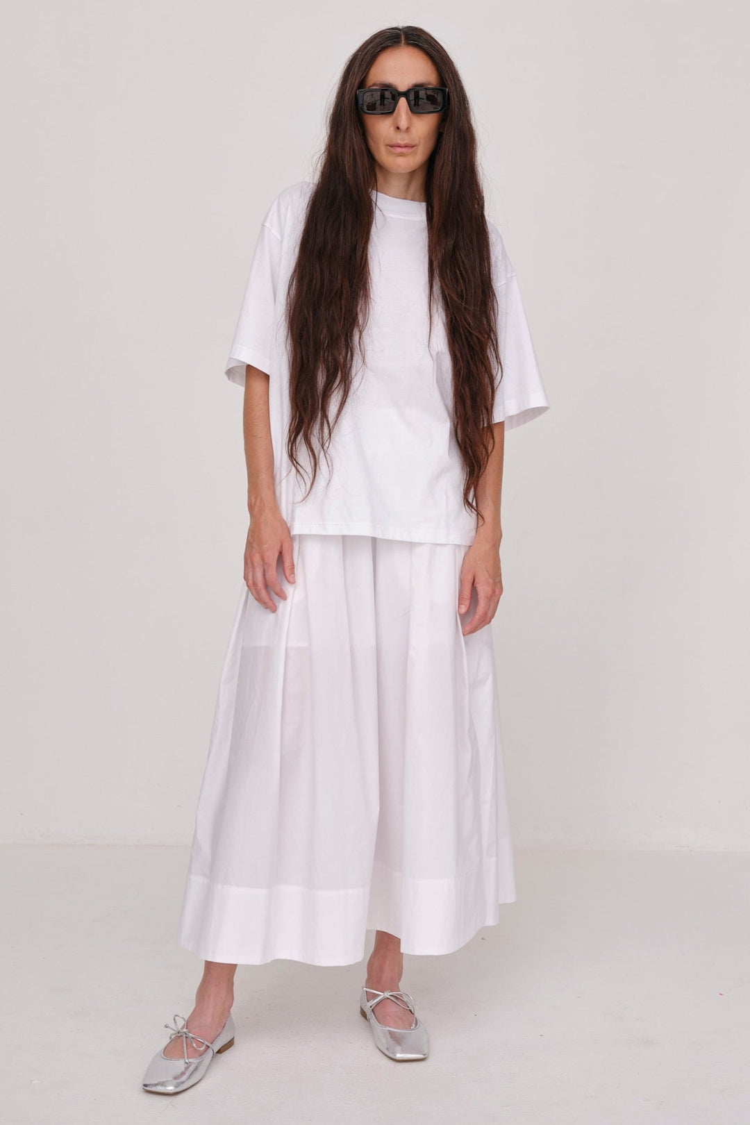 Herskind Herdis Skirt i hvid – lang, let nederdel i 100 % BCI-certificeret bomuld med elastisk talje, plisseret front og slidser i siderne. 