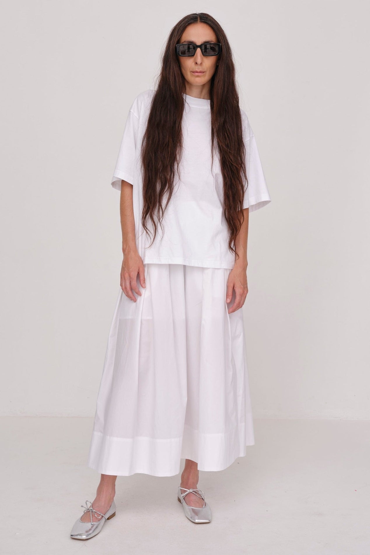 Herskind Herdis Skirt i hvid – lang, let nederdel i 100 % BCI-certificeret bomuld med elastisk talje, plisseret front og slidser i siderne. 