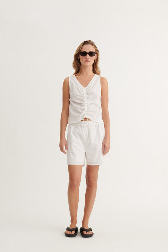 Basic Apparel Lotus Top i 100 % økologisk bomuld med broderet stof, bindebånd til to stylingmuligheder og afslappet fit. Bæredygtig og alsidig top. 