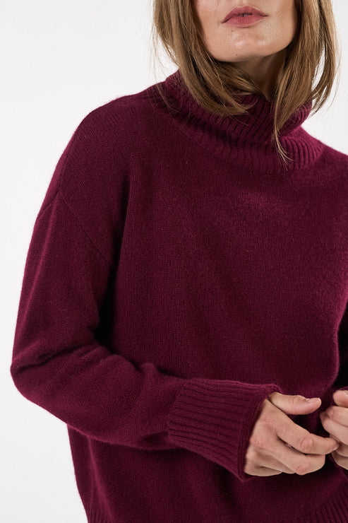 Otay Merle Jumper i farven Bordeaux, strikket i 100% cashmere, med rullekrave og ribdetaljer.