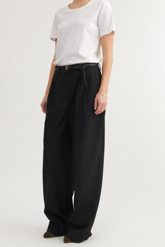 Basic Apparel Marjo Pants i sort – bukser i genanvendt polyester med læg foran, vide ben, skrålommer og justerbar talje.
