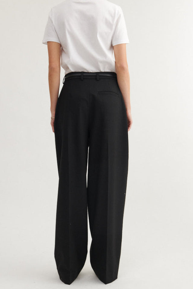 Basic Apparel Marjo Pants i sort – bukser i genanvendt polyester med læg foran, vide ben, skrålommer og justerbar talje.
