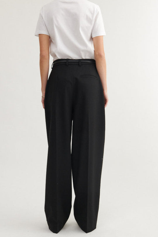 Basic Apparel Marjo Pants i sort – bukser i genanvendt polyester med læg foran, vide ben, skrålommer og justerbar talje.
