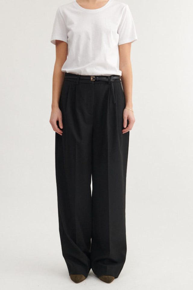 Basic Apparel Marjo Pants i sort – bukser i genanvendt polyester med læg foran, vide ben, skrålommer og justerbar talje.
