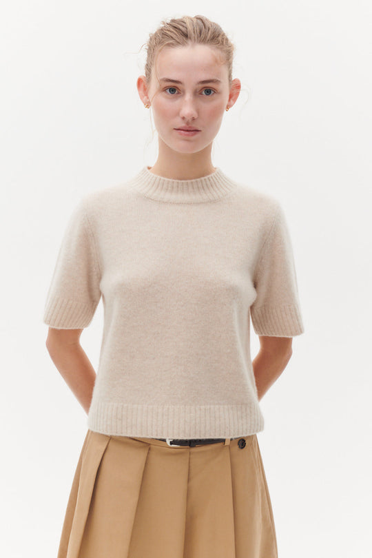 Beta Studios Mie Short Sleeves strikbluse i Eco Alabast White – kort cashmere top med turtleneck og brede ribbede kanter.
