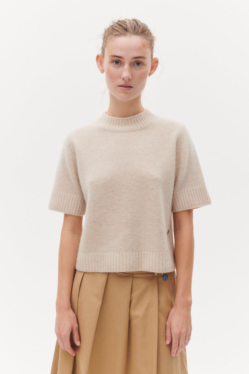 Beta Studios Mie Short Sleeves strikbluse i Eco Alabast White – kort cashmere top med turtleneck og brede ribbede kanter.
