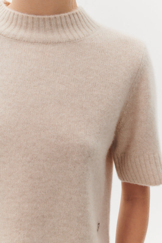  Beta Studios Mie Short Sleeves strikbluse i Eco Alabast White – kort cashmere top med turtleneck og brede ribbede kanter.
