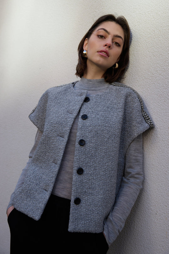 PBO Kino Cape i light grey – kort cape med rund hals og perle-detaljer over skuldrene.
