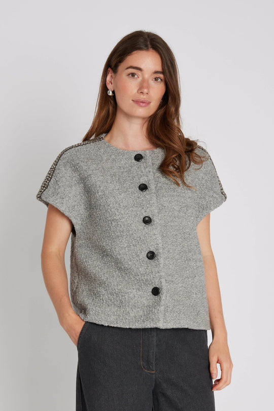 PBO Kino Cape i light grey – kort cape med rund hals og perle-detaljer over skuldrene.
