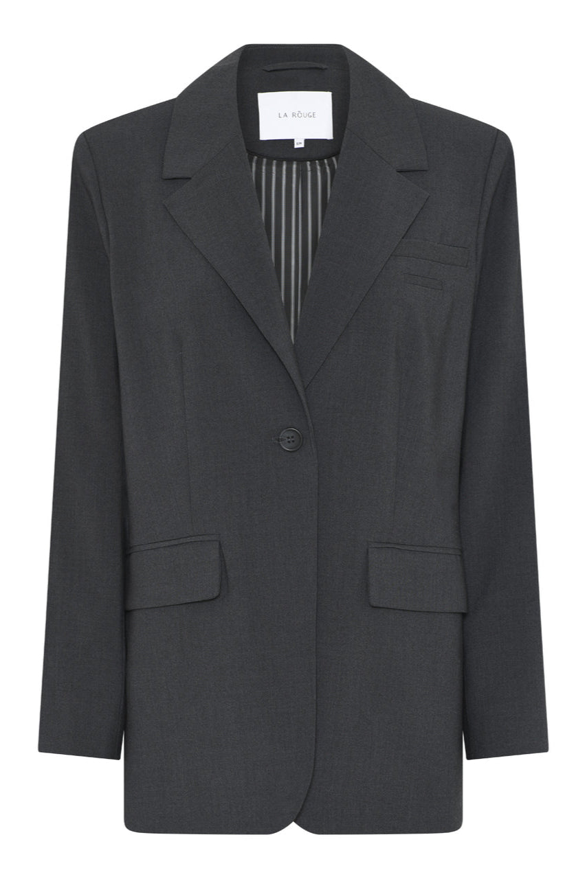 La Rouge Trine Blazer i dark grey med enkelknaplukning, reverskrave og let oversized pasform – stilfuld og alsidig til både hverdag og fest.
