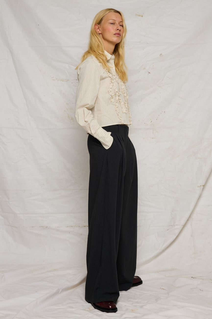 La Rouge Trine Pants i dark grey – elegante bukser med høj talje, brede ben, pressefolder, bæltestropper og skjult lukning.
