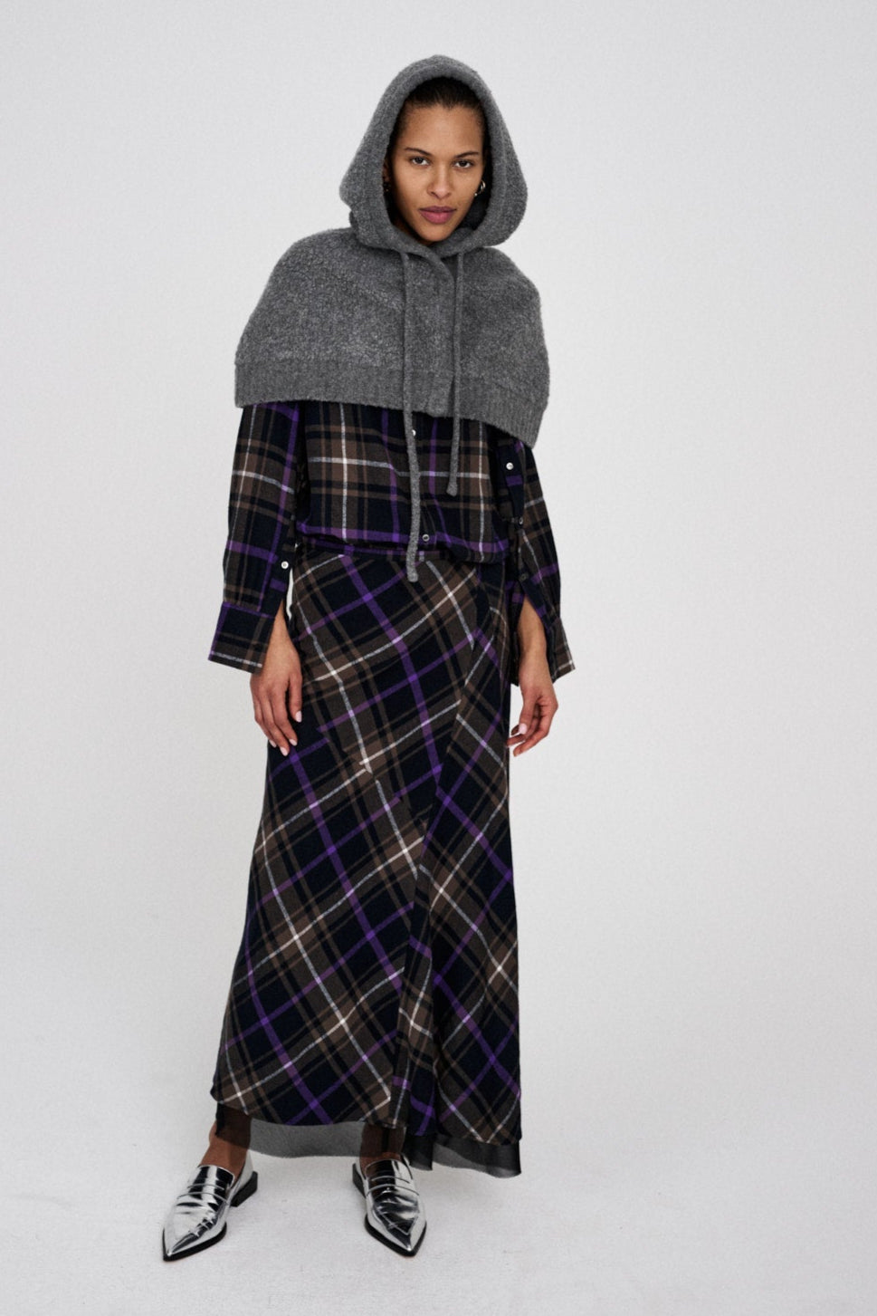 Sinika Sheep Knit Hood i grå med oversized hætte, knaplukning foran og snoretræk – uldblandet hue/hætte til både praktisk og dekorativ brug.
