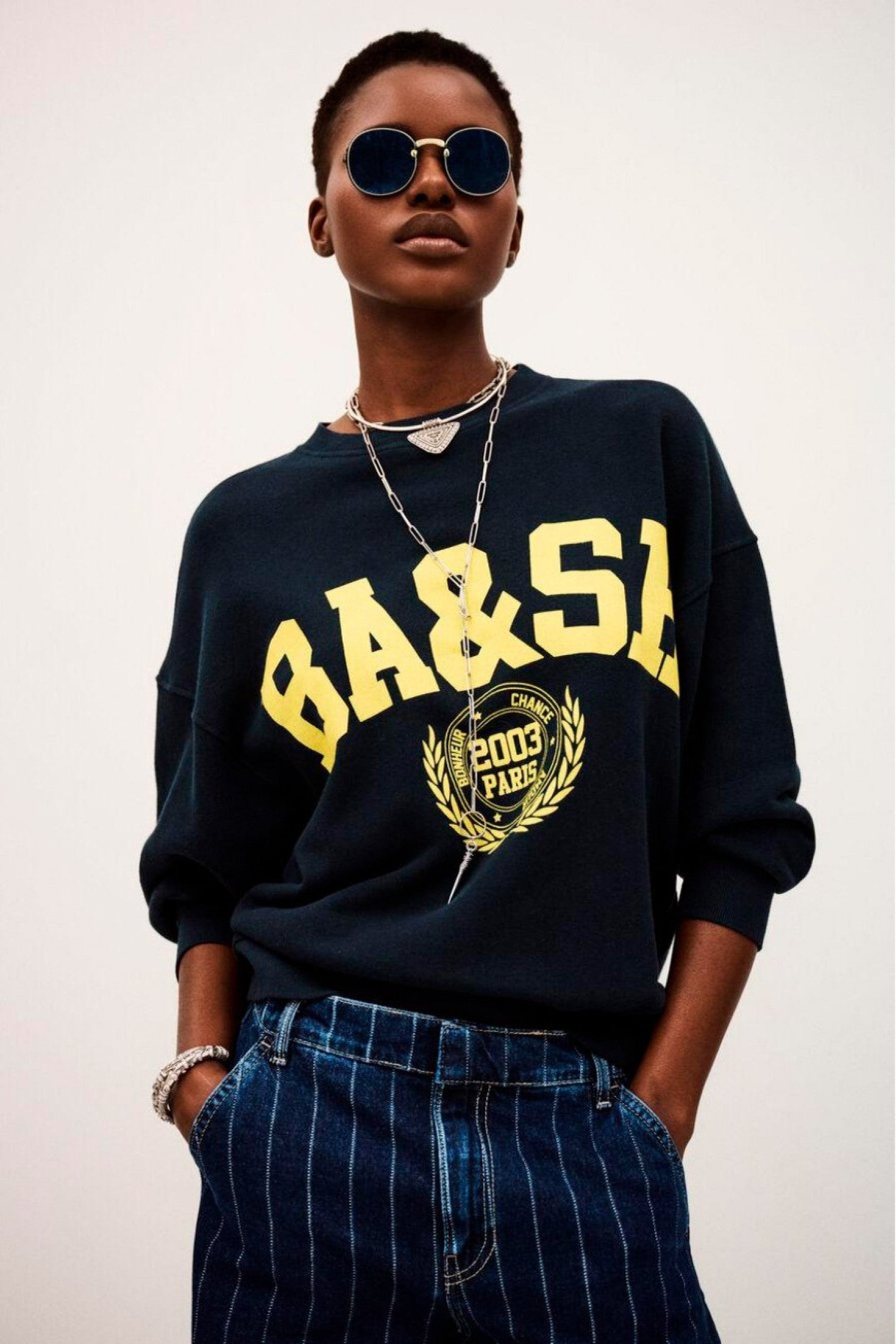 Benjamin sweatshirt i bleu med løs pasform, kort længde og college-inspireret logo. Lavet i økologisk bomuld med stræk. 