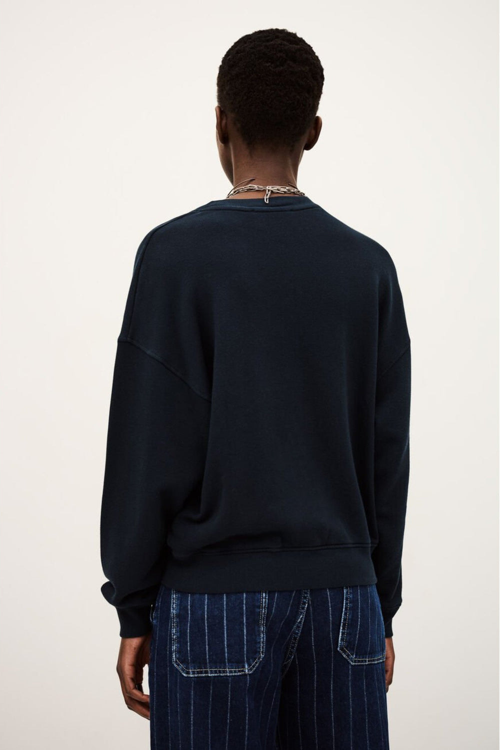 Benjamin sweatshirt i bleu med løs pasform, kort længde og college-inspireret logo. Lavet i økologisk bomuld med stræk. 